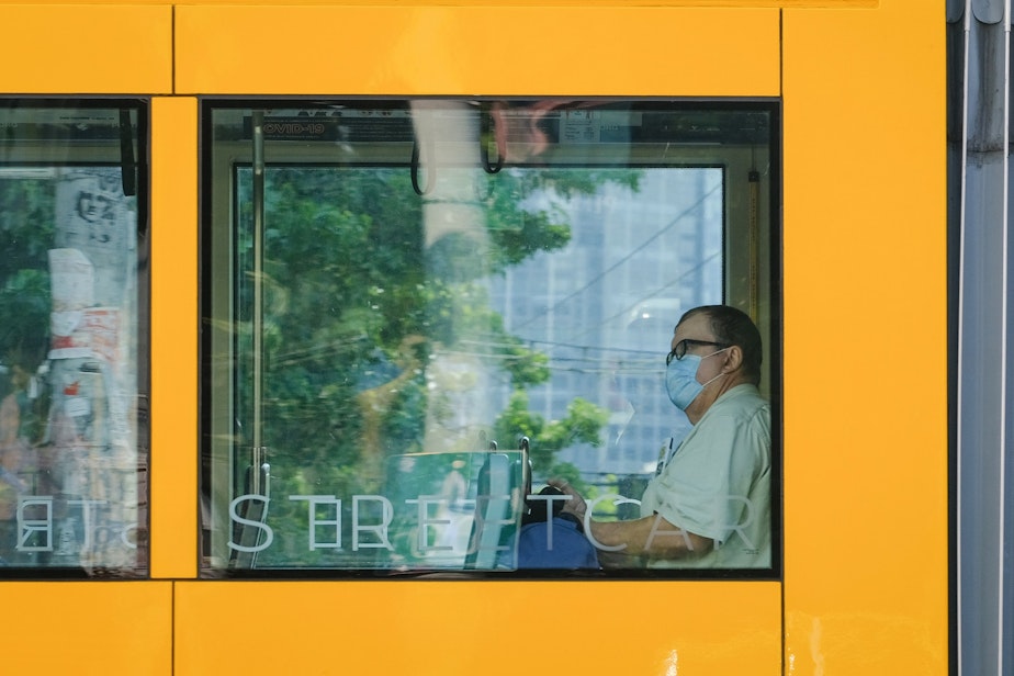 caption: A masked passenger rides the street car through Capitol Hill, August 2, 2021. Masks remain a requirement on Seattle public transit, including busses and street cars.