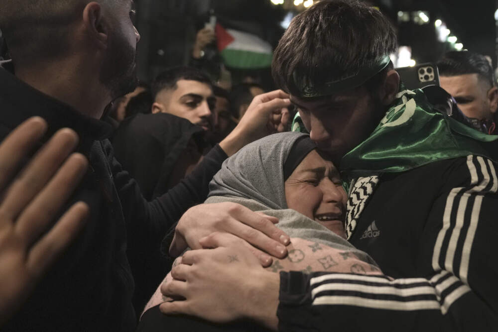 caption: Omar Atshan, 17, is hugged by his mother after being released from an Israeli prison in the West Bank town of Ramallah, Sunday Nov. 26, 2023. (Nasser Nasser/AP)