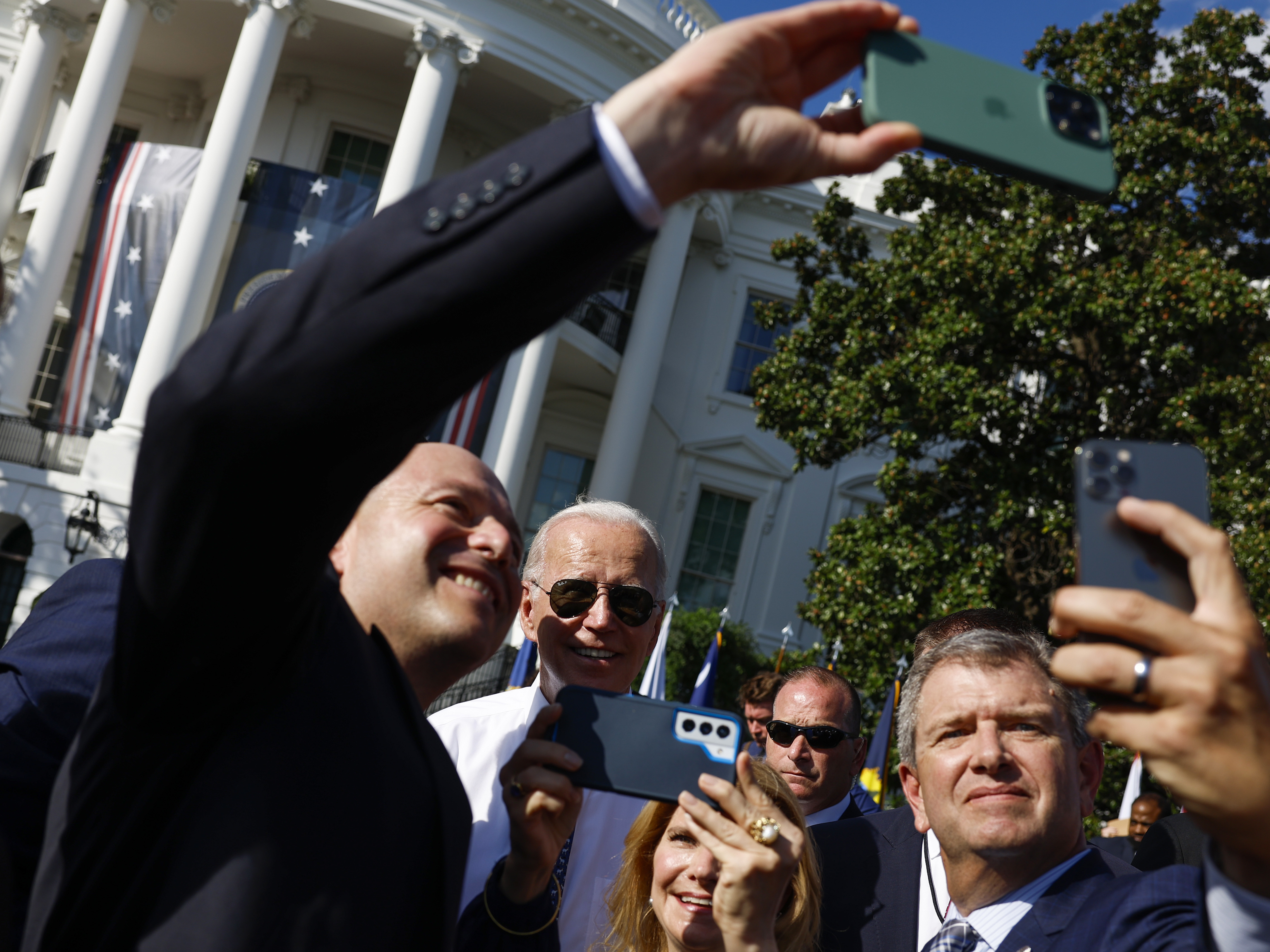 caption: President Biden takes pictures with guests after speaking at an event celebrating the passage of the Inflation Reduction Act on the South Lawn of the White House on Sept. 13.