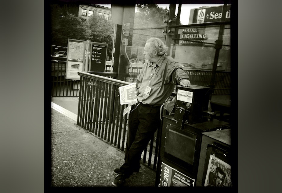 caption: A man sells Real Change in Seattle; soon vendors will be more common in Bellevue locations as well.