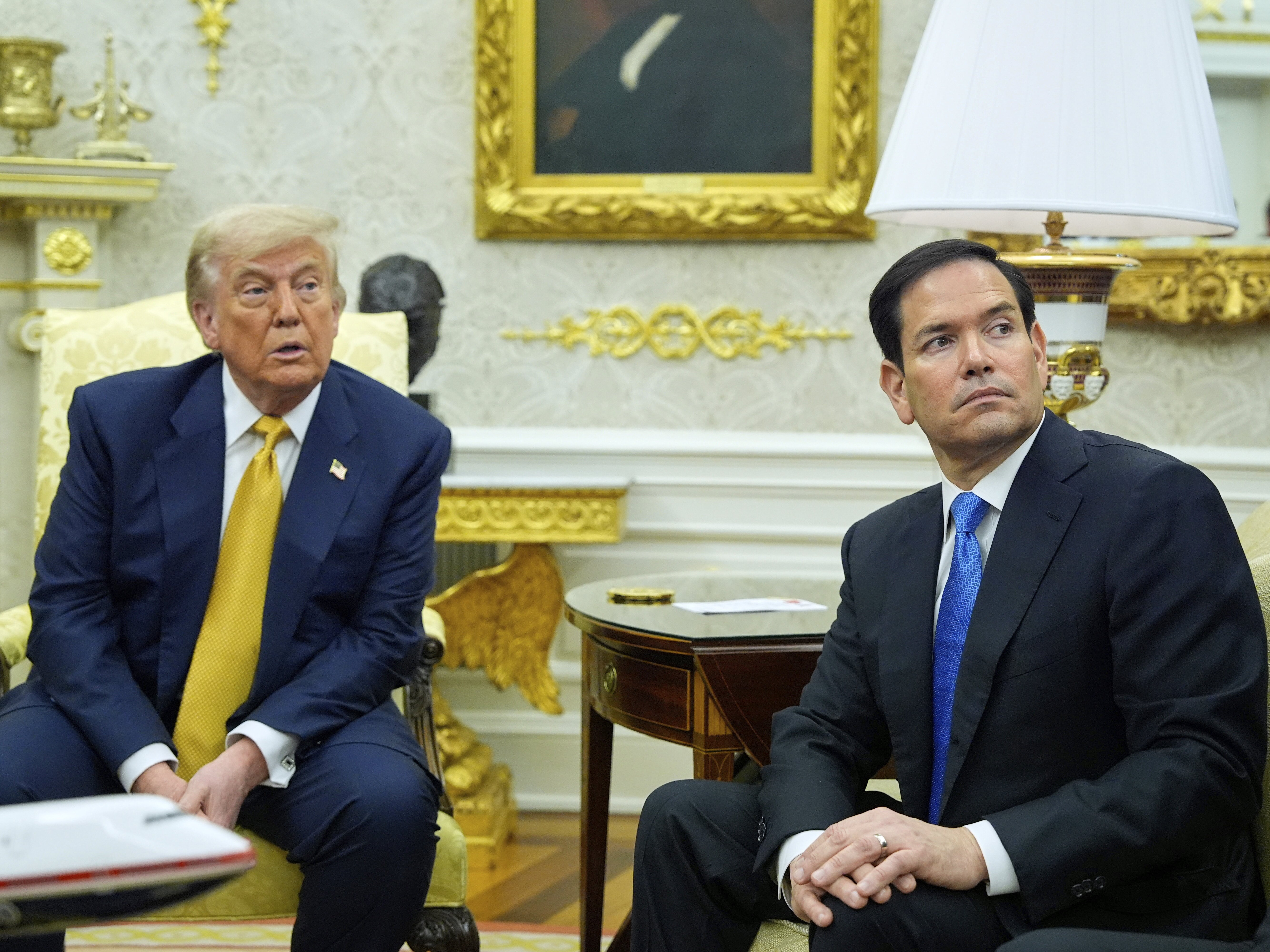 caption: President Trump and Secretary of State Marco Rubio listen during an Oval Office meeting at the White House on July 16.