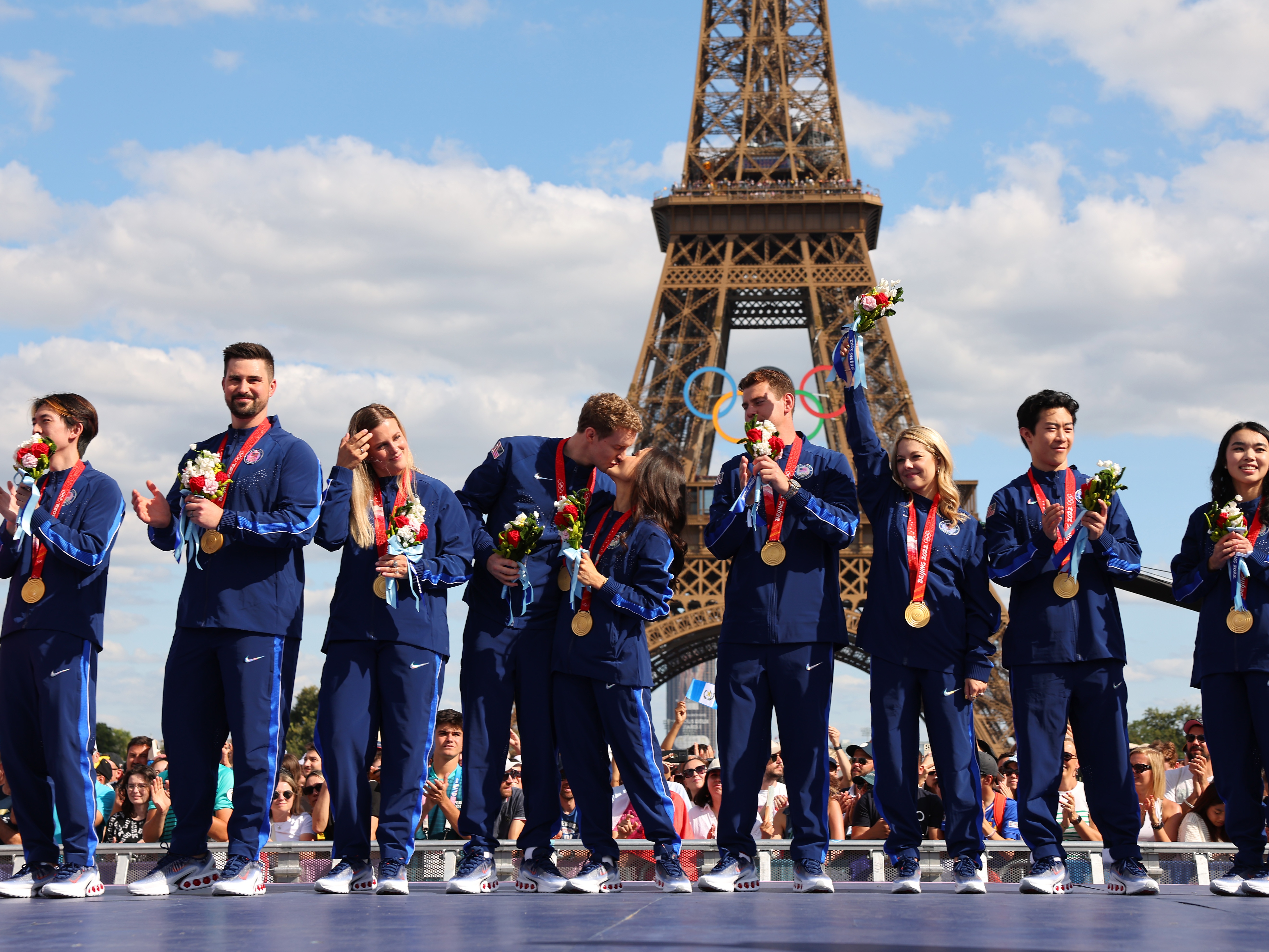 caption: Two years after they won, members of the U.S. figure skating team celebrate their victory and receive their gold medals won during the 2022 Beijing Winter Olympics. The delayed ceremony, held during the Paris Summer Games, follows the recent disqualification of Russia following a doping controversy.