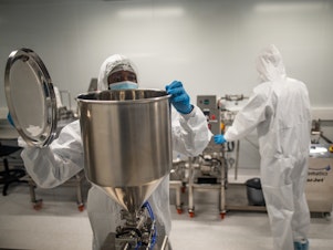 caption: Members of a team at the Afrigen Biologics and Vaccines lab in Cape Town, South Africa. The World Health Organization has enlisted the company to replicate Moderna's COVID-19 vaccine.