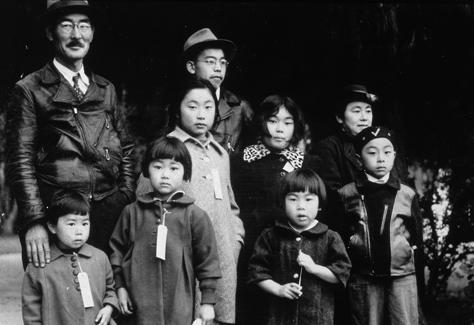 caption: Members of the Japanese American Mochida family, in Hayward, Calif., await relocation to an incarceration camp during World War II.