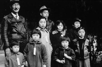 caption: Members of the Japanese American Mochida family, in Hayward, Calif., await relocation to an incarceration camp during World War II.