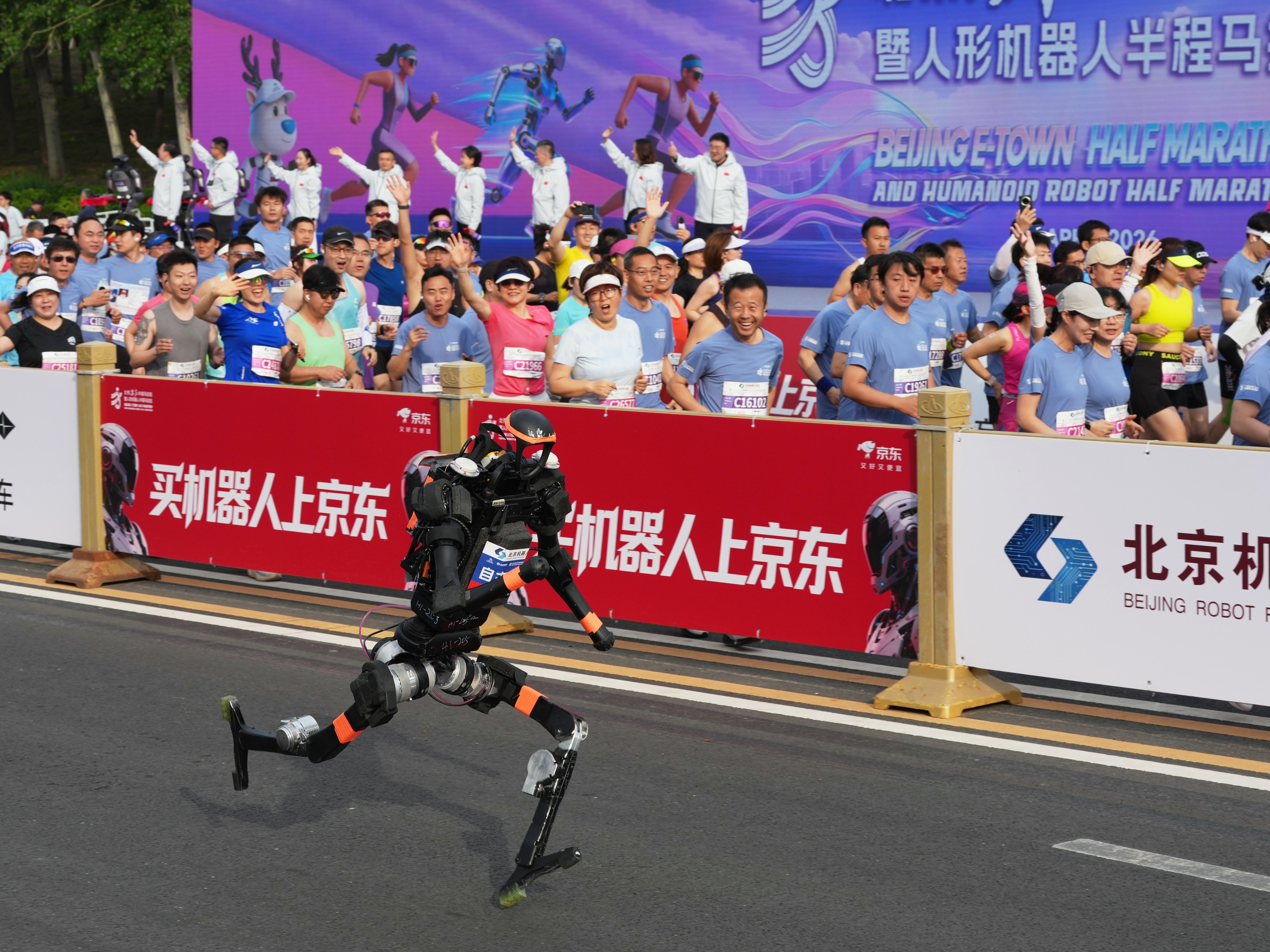 caption: A robot starts off for the Beijing E-Town Half Marathon and Humanoid Half Marathon on the outskirts of Beijing on Sunday, April 19, 2026.