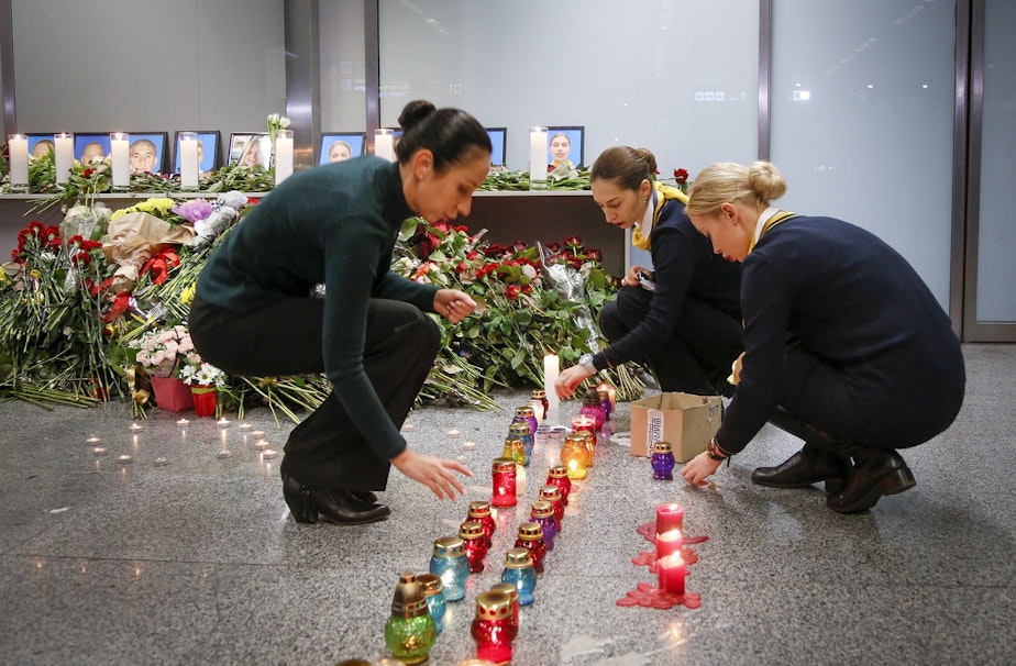 caption: Colleagues of the flight crew members of the Ukrainian 737-800 plane that crashed on the outskirts of Tehran, light candles at a memorial inside Borispil International Airport near Kyiv on Wednesday.