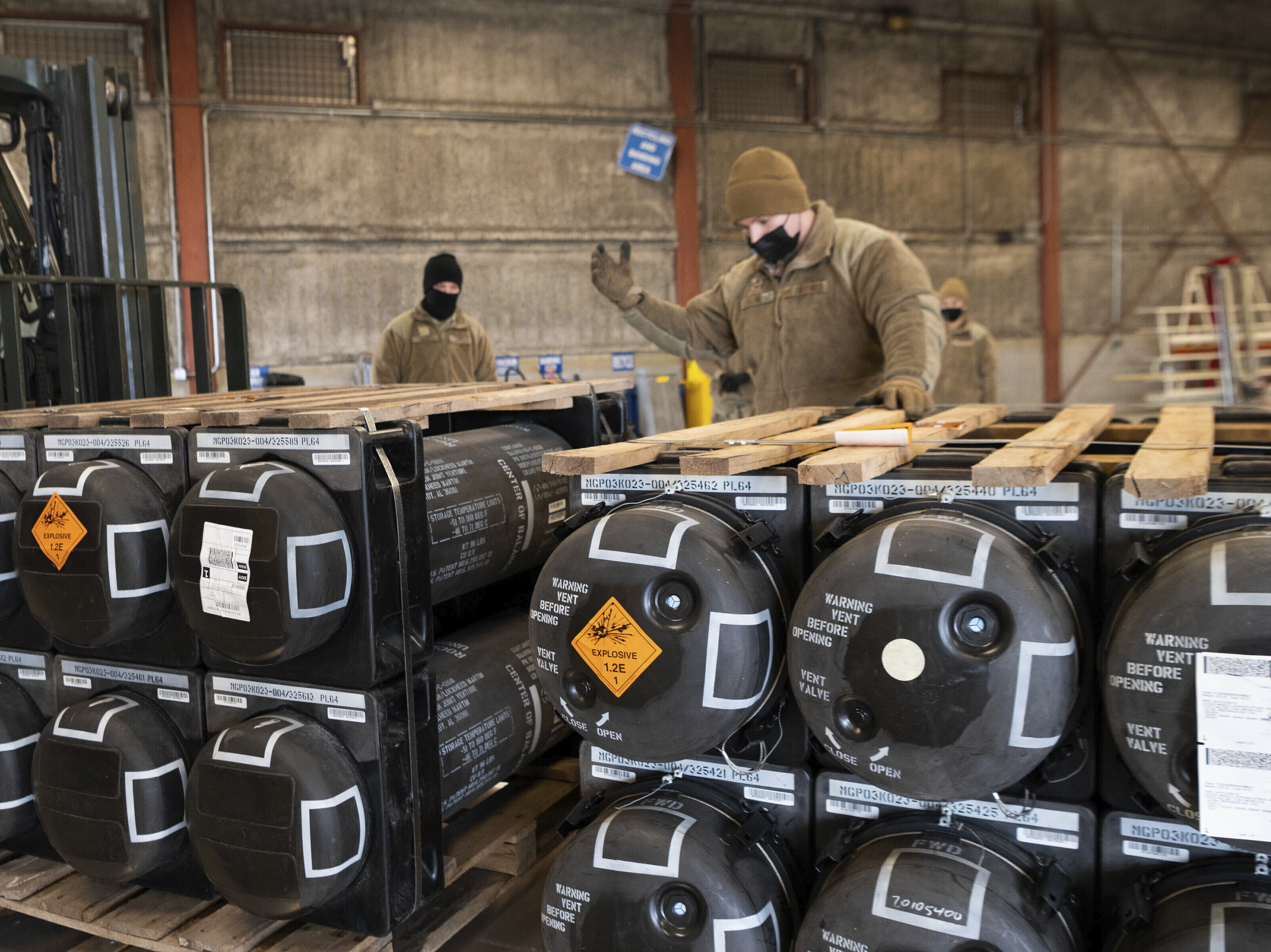 caption: Airmen and civilians from the 436th Aerial Port Squadron place ammunition, weapons and other equipment on pallets bound for Ukraine at Dover Air Force Base in Delaware on Jan. 21, 2022.