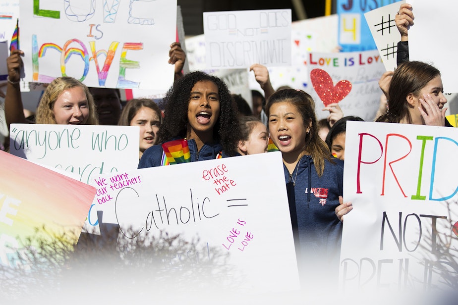 caption: Sosna Araya, center, a junior at Kennedy Catholic High School and member of the soccer team chants with classmates during a walkout to protest the departure of two LGBT educators on Tuesday, February 18, 2020, at Kennedy Catholic High School in Burien.