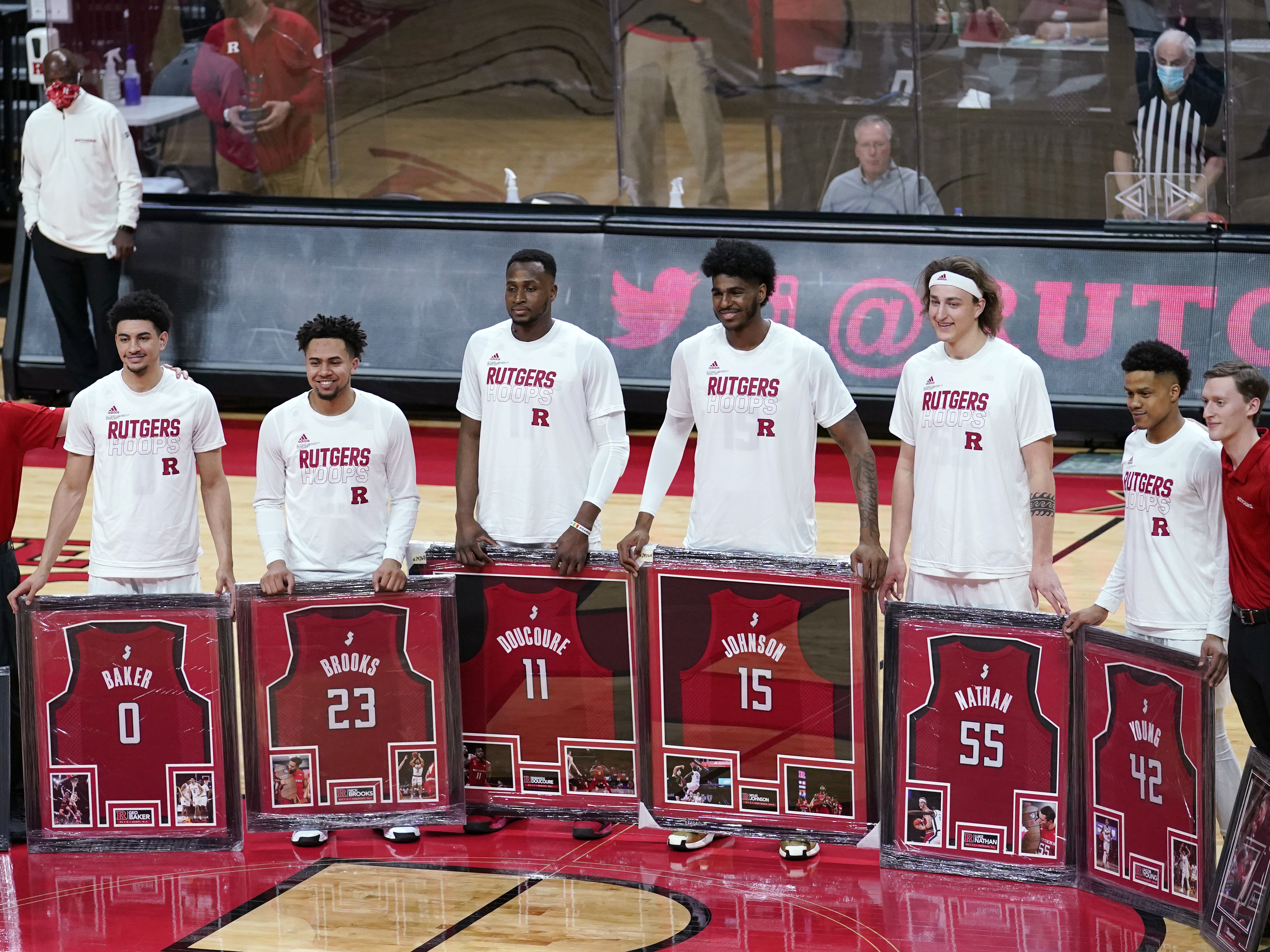 caption: Senior night at Rutgers, where graduating seniors received framed jerseys and applause at the last home game of their careers. Though graduation rates have improved over time, Black basketball players in the NCAA's top division graduate at a rate about 13 percentage points lower than their white teammates.