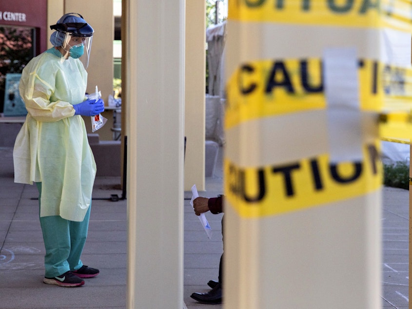 caption: A doctor stands at a walk-up coronavirus testing site at West County Health Center in San Pablo, Calif. in April 2020. Pandemic burnout has effected thousands of health care workers.