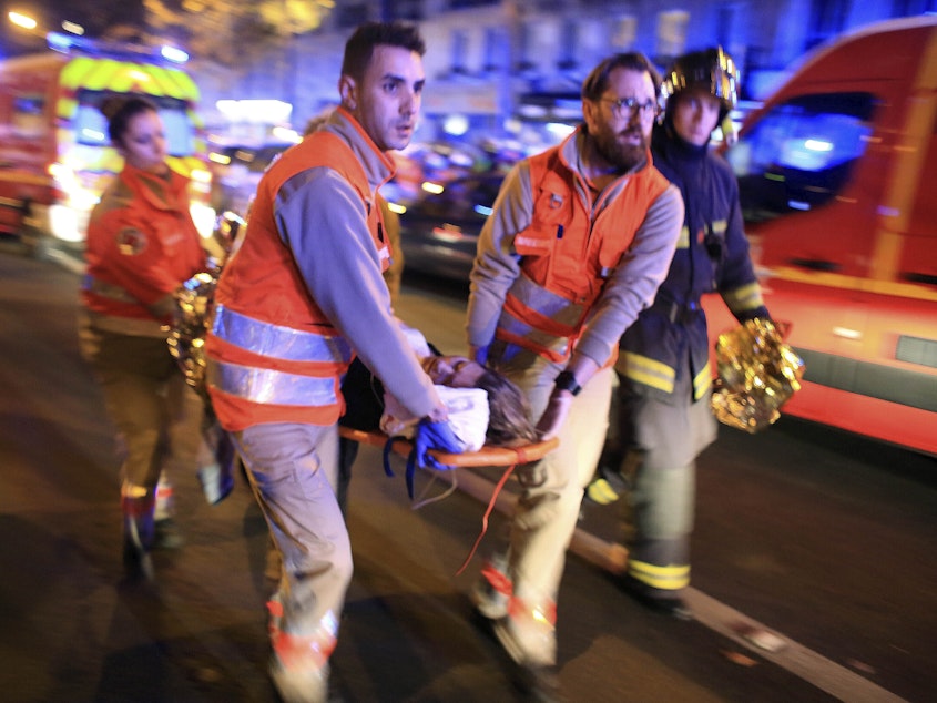 caption: A woman is evacuated from the Bataclan concert hall in Paris after a shooting on Nov. 13, 2015.