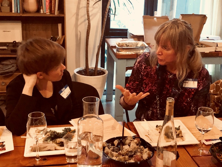 caption: Queeriosity Club members Dacia Clay (left) and Jennifer Hegeman talk during KUOW's first Pride-themed Curiosity Club dinner at The Cloud Room in Seattle. June 7, 2019.