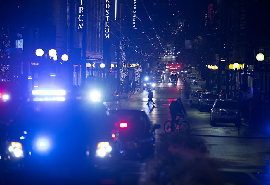 caption: Patrol cars and ambulances are shown at the intersection of Third Avenue and Pine Street on Wednesday, January 22, 2020, following a shooting that left multiple victims injured and one dead in Seattle.