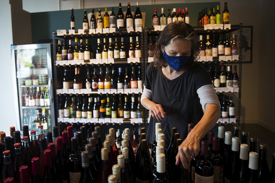 caption: Co-owner of Petite Soif Shawn Mead arranges wine bottles on Thursday, July 16, 2020, in Seattle. 