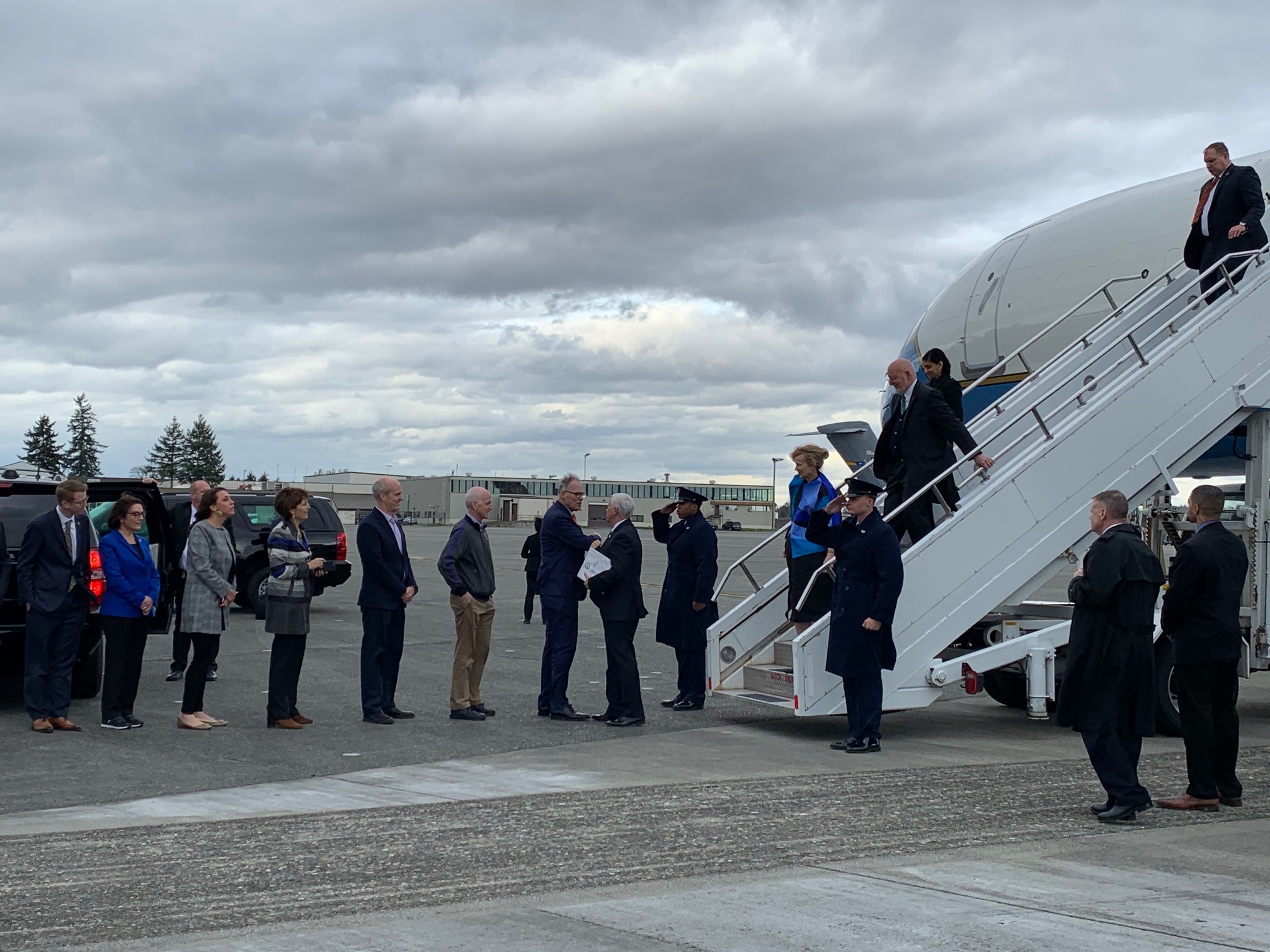 caption: Wash. Gov. Jay Inslee greets the arrival of Vice President Mike Pence in Washington state with an elbow bump