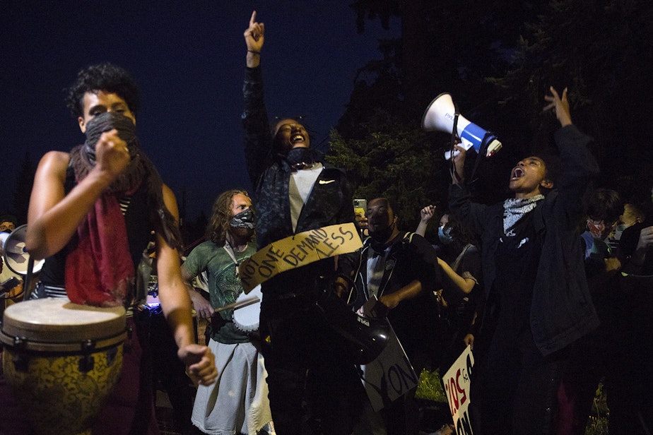 caption: Organizers of the Everyday March, Tealshawn Turner, also known as TK, center, and Katie Neuner, dance along to the EDM Band while marching on a public street toward Seattle City Councilmember Debora Juarez's home in an effort to have a dialogue about racial justice and police brutality on Tuesday, August 4, 2020, in Seattle. Councilmember Juarez did not come outside and the group spoke with the councilmember's daughter Memphis instead.
