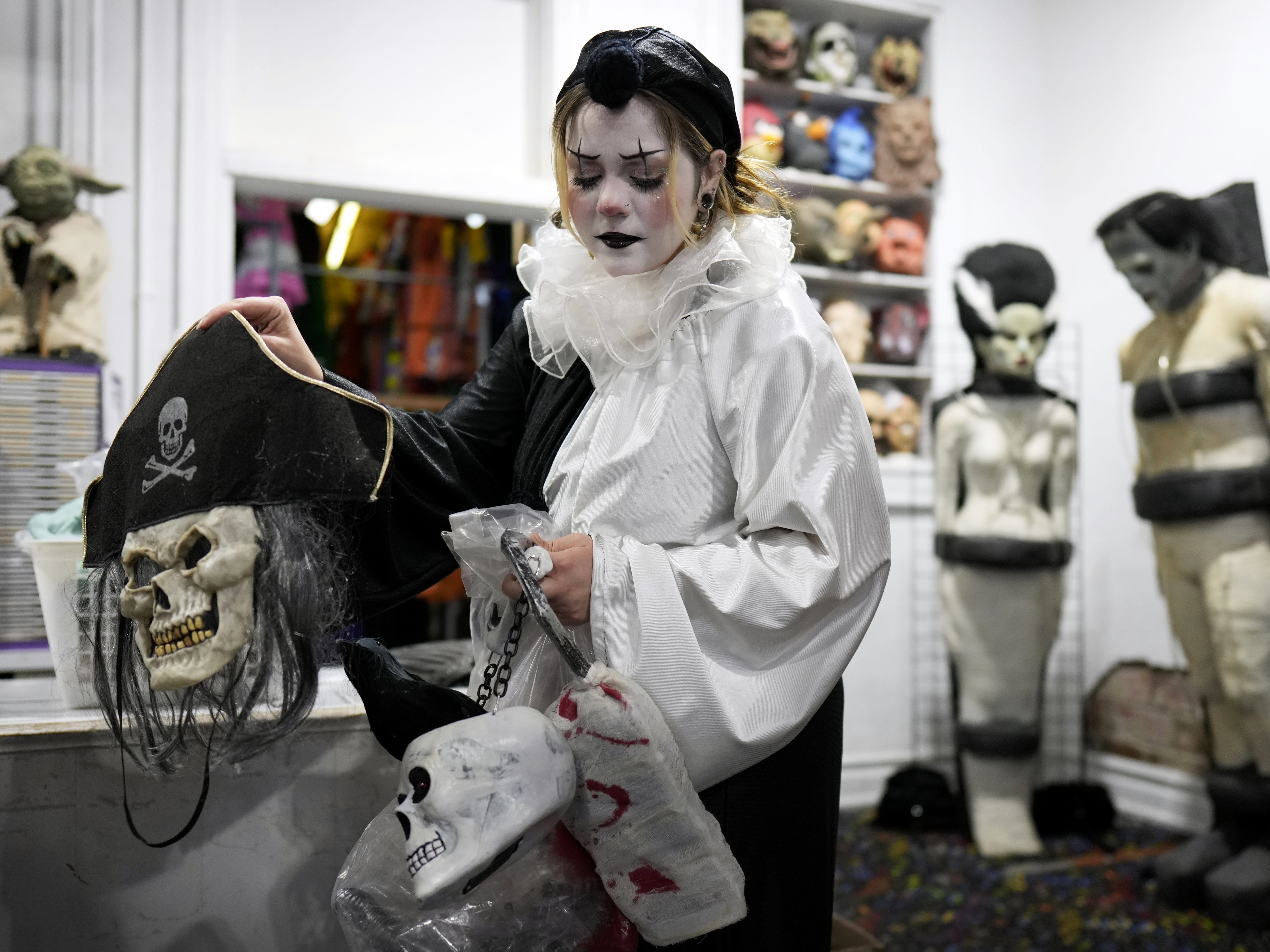caption: Olive Luther prepares to stock costume displays at The Theatrical Shop, Tuesday, Oct. 29, 2024, in West Des Moines, Iowa.
