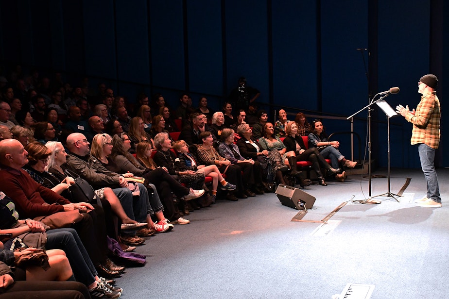 caption: Dean Burke performs his story, "The Eyes Have It," at KUOW's Stories from THE WILD event on Friday, October 11, 2019, at McCaw Hall in Seattle.