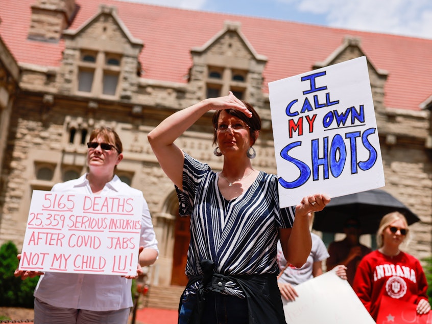 caption: People protest against mandatory COVID-19 vaccinations at Indiana University in June.