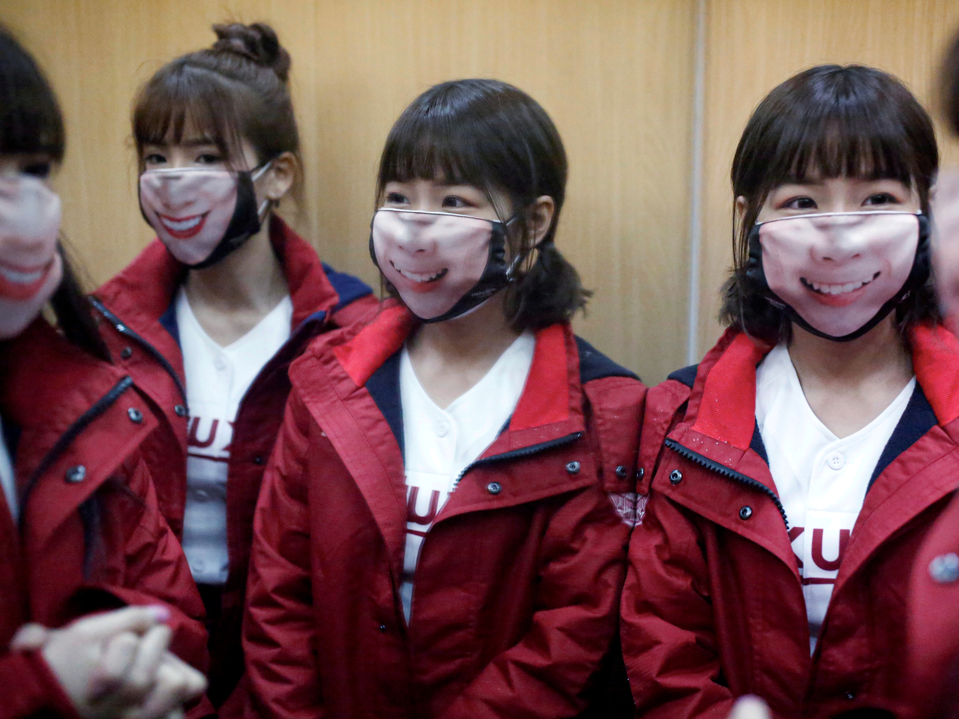 caption: Cheerleaders wore face masks as Taiwan recently prepared for the the first professional baseball league game of the season. The island has emerged as a success story in containing coronavirus, avoiding the need for a strict lockdown.
