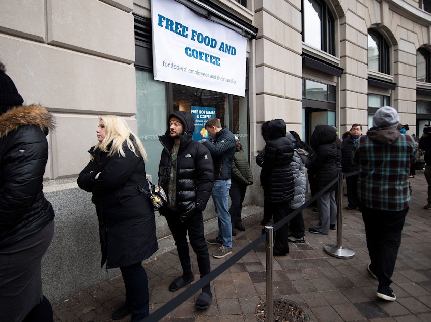 caption: Federal workers stand in line for a free hot meal in Washington, D.C., on Wednesday.