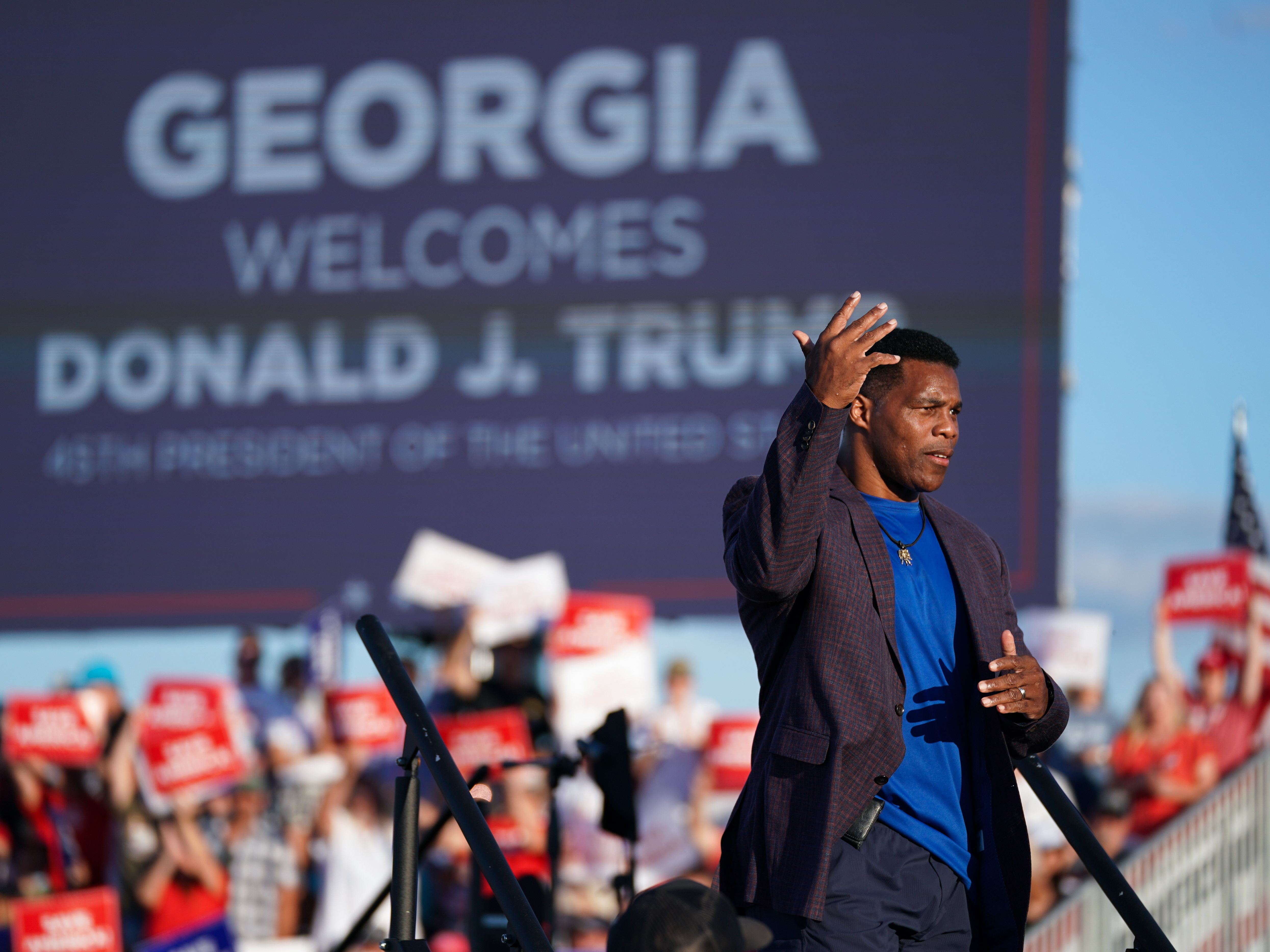 caption: Republican Senate candidate Herschel Walker walks off the stage during a rally featuring former President Donald Trump on Sept. 25 in Perry, Georgia.