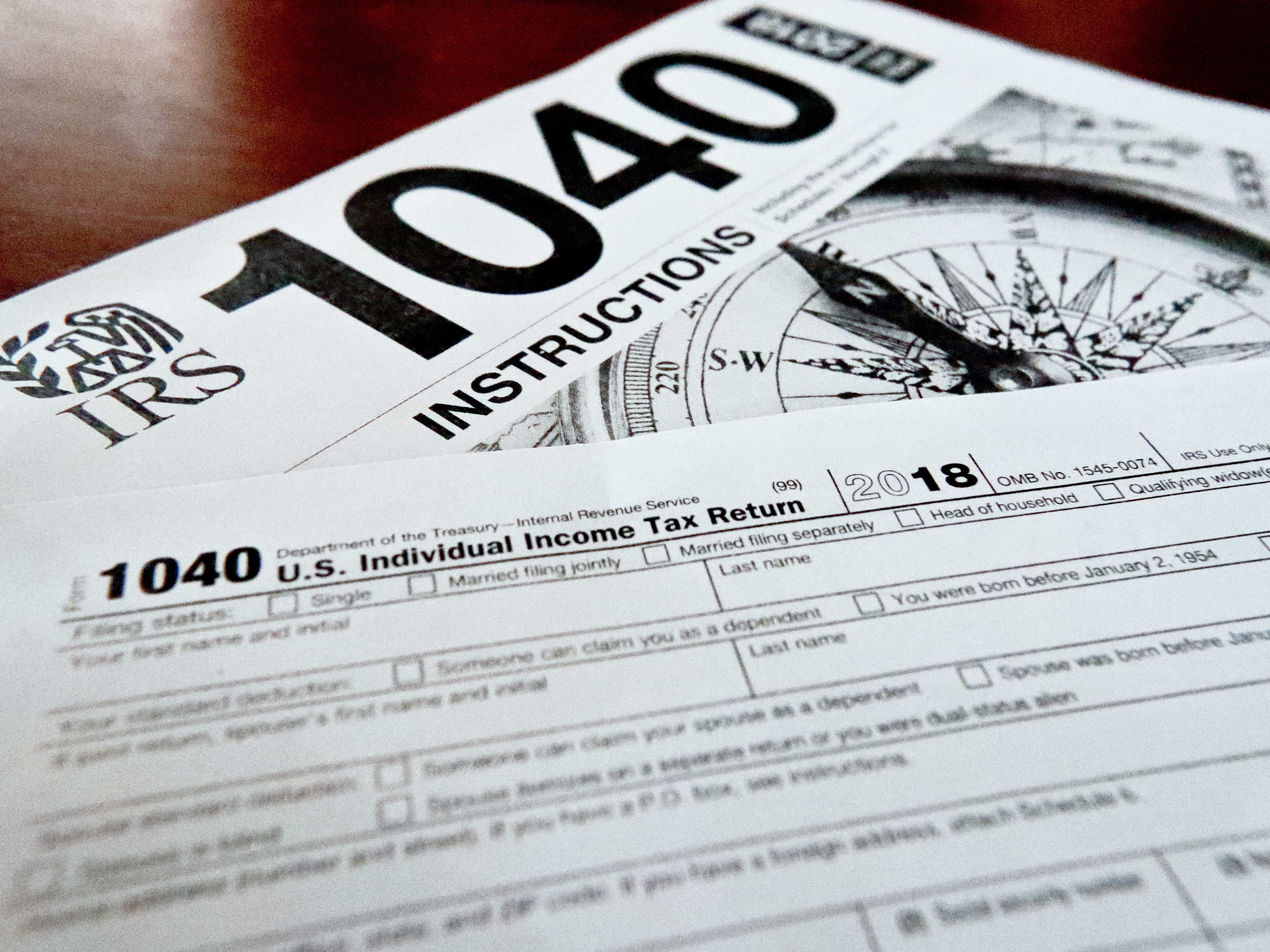 caption: Internal Revenue Service tax forms are seen on a table. Black married couples are dealing with higher penalties compared with white married couples, a new report indicates.