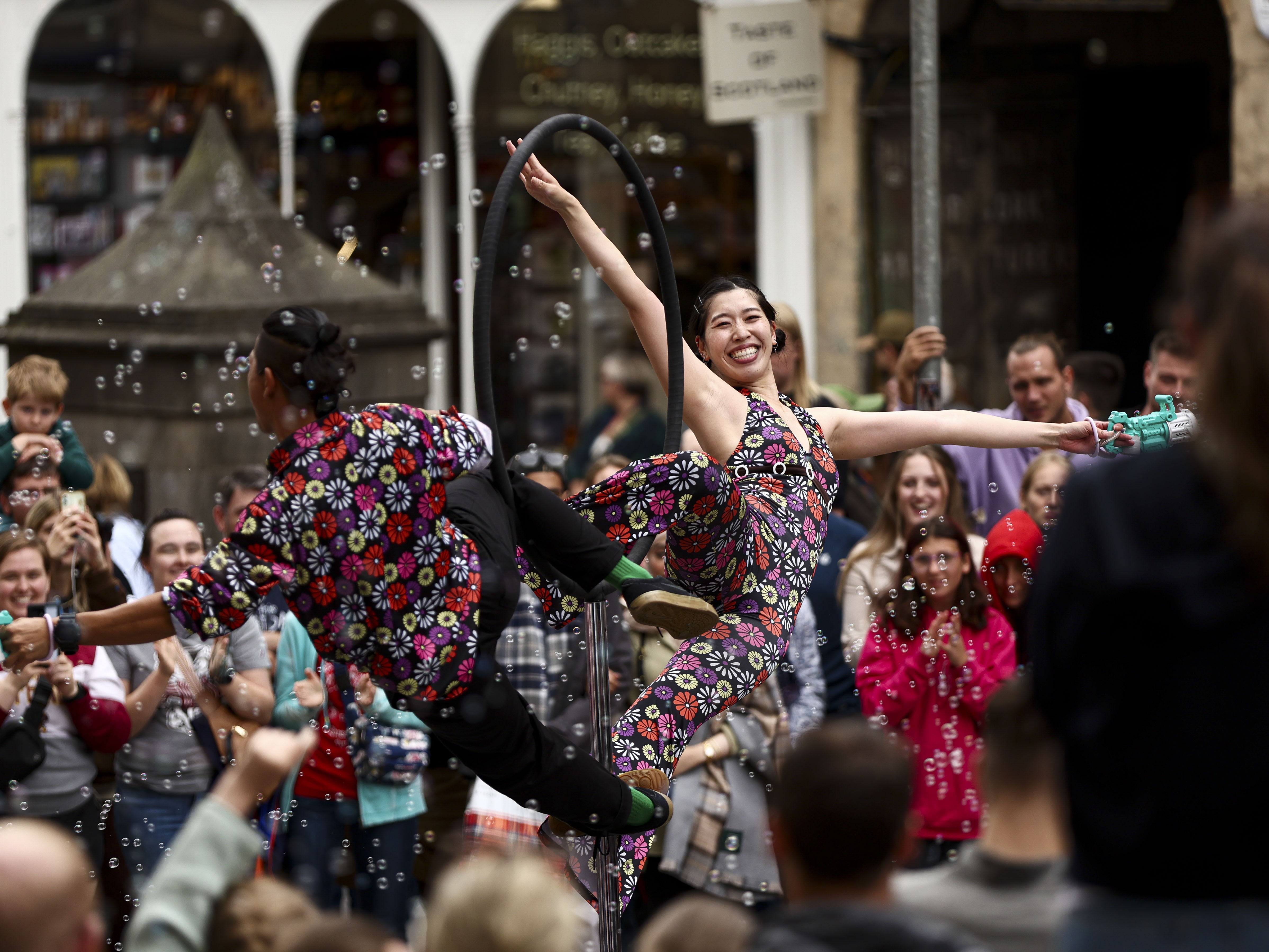 caption: Street performers entertain passersby on the Royal Mile as crowds of entertainers and festival-goers gather for the Edinburgh Festival Fringe and Edinburgh International Festival in Edinburgh, Scotland, on Aug. 1, 2025. The Fringe, one of the world's largest performing arts festivals, features over 3,800 shows across 265 venues and draws an audience of roughly 3 million visitors.