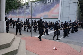 caption: A police line approaches demonstrators in downtown Louisville, Ky., last week during protests over the lack of criminal charges in the police killing of Breonna Taylor and the result of a grand jury inquiry.