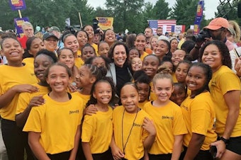 caption: Kamala Harris poses with the Isiserettes, a legendary drill-and-drum team, at the Polk County Steak Fry in Iowa in 2019.