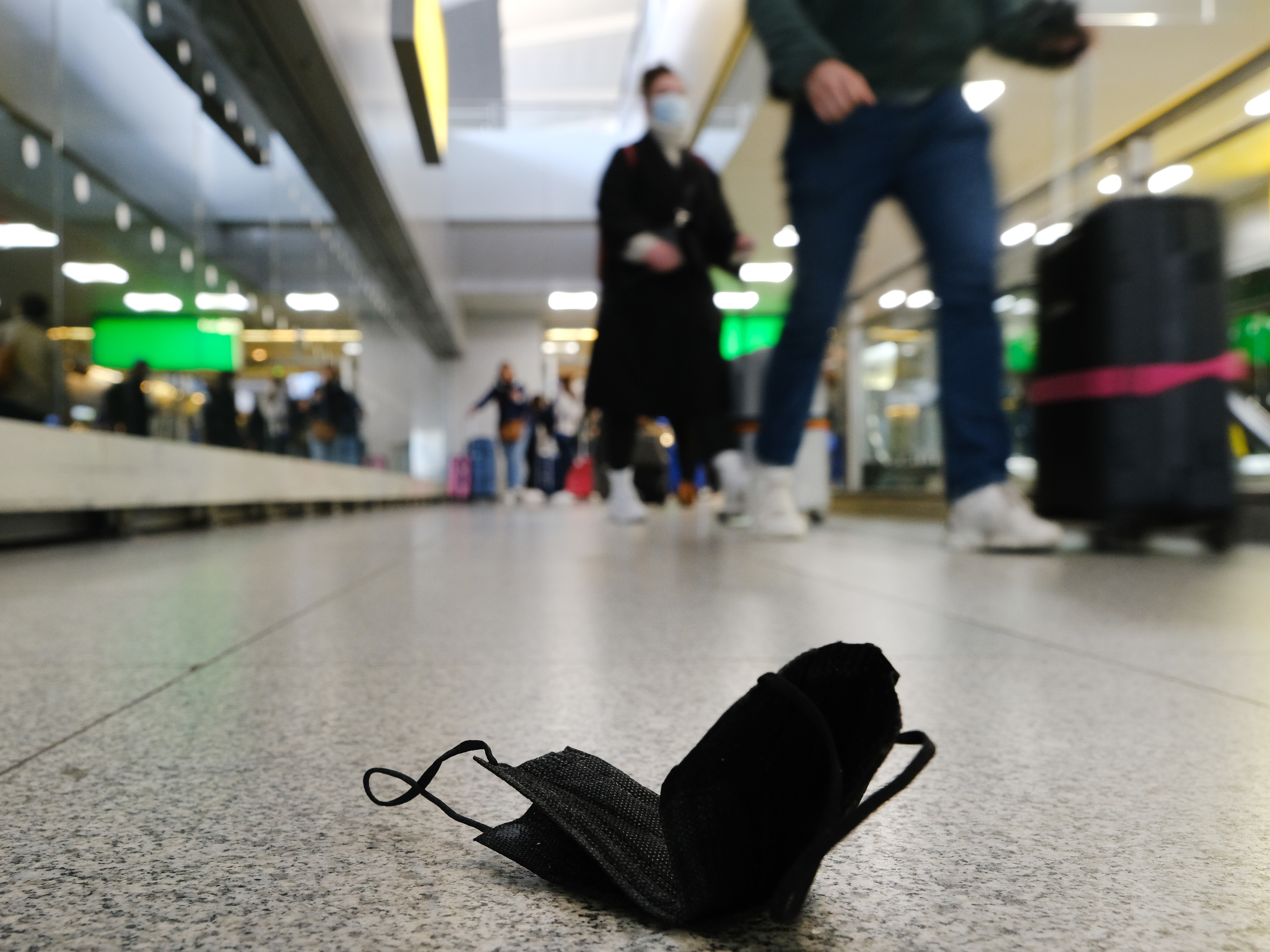caption: A mask is seen on the ground at John F. Kennedy Airport in New York City. On Monday, a federal judge in Florida struck down the mask mandate for airports and other methods of public transportation as a new COVID variant is on the rise across parts of the United States.