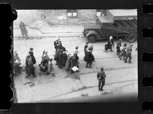 caption: This handout negative dated on April 20, 1943, and taken by Polish firefighter Zbigniew Leszek Grzywaczewski shows Jewish people being evacuated from the Warsaw Ghetto.