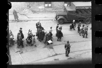 caption: This handout negative dated on April 20, 1943, and taken by Polish firefighter Zbigniew Leszek Grzywaczewski shows Jewish people being evacuated from the Warsaw Ghetto.
