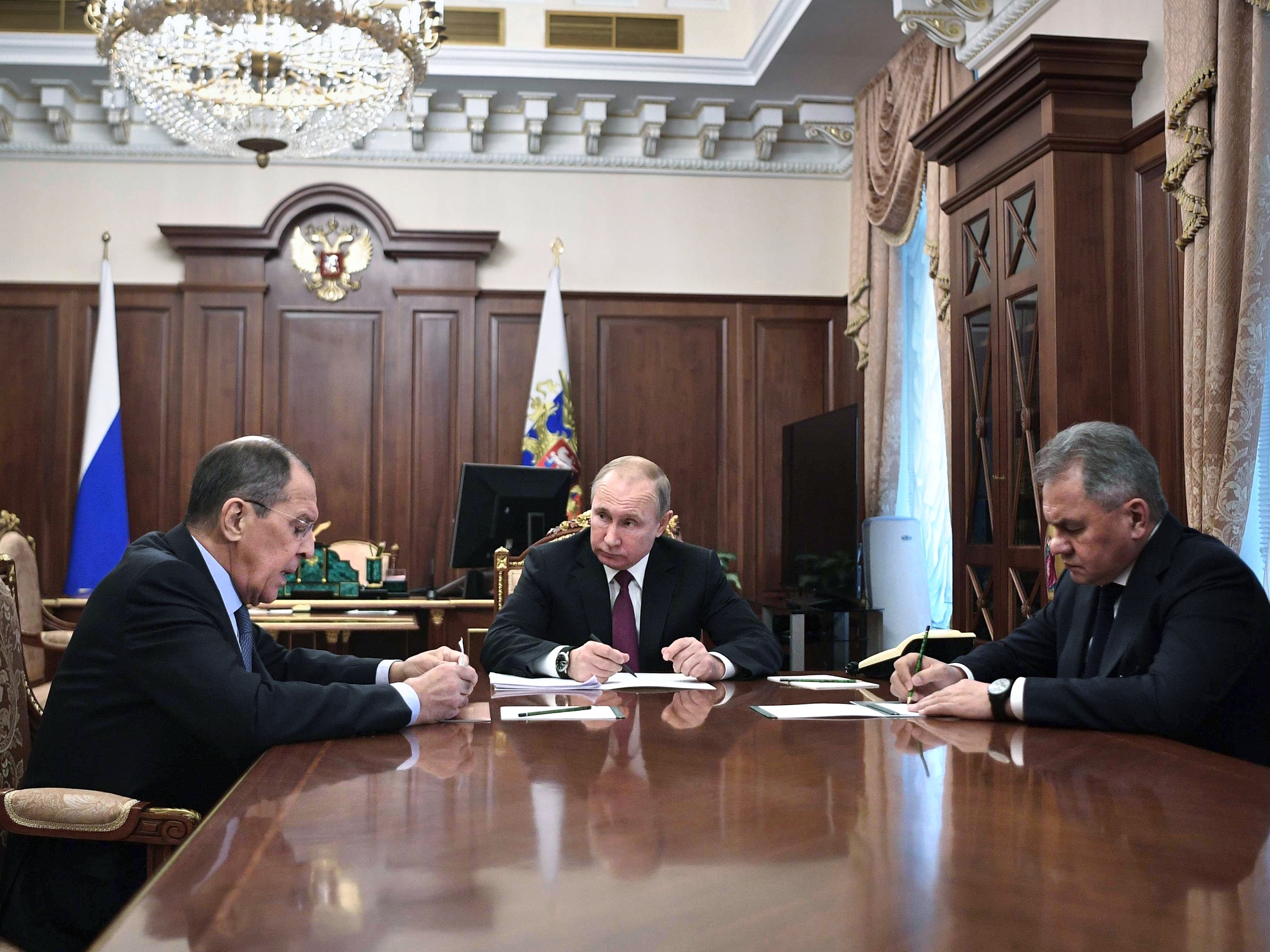 caption: Russian President Vladimir Putin (center) attends a meeting with Russian Foreign Minister Sergey Lavrov (left) and Defense Minister Sergei Shoigu in the Kremlin in Moscow on Saturday. Putin said Russia would abandon the 1987 Intermediate-Range Nuclear Forces treaty, calling it a "symmetrical" response to the U.S. decision to withdraw.