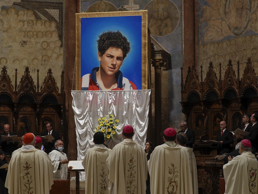 caption: An image of 15-year-old Carlo Acutis is unveiled during his beatification ceremony at the St. Francis Basilica in Assisi, Italy, in October 2020.  