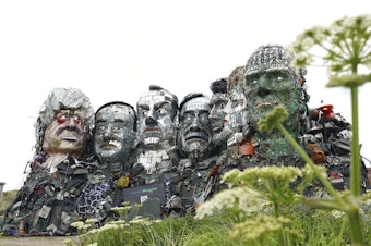 caption: A sculpture created out of electronic waste in the likeness of Mount Rushmore and the G-7 leaders sits on a hill in Cornwall, England, near where the leaders of the world's wealthiest nations will meet.