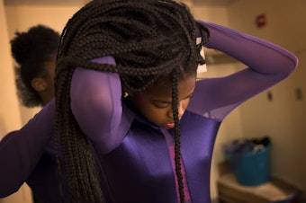 caption: Yizjuani Watson, 11, has help with her costume from Simya Gibson, 13, during a rehearsal on Tuesday, May 15, 2018, at Rainier Beach high school in Seattle.