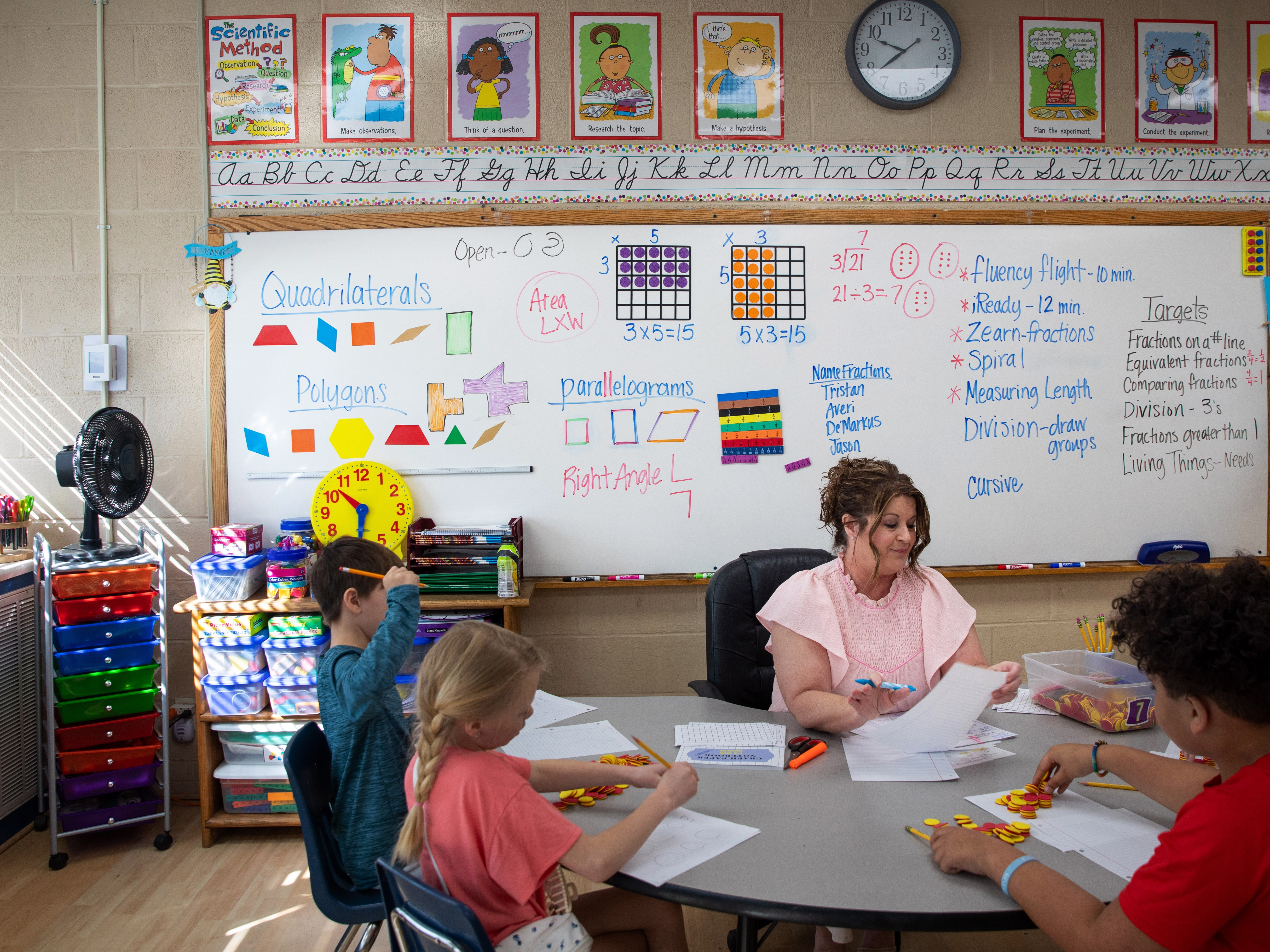caption: Math teacher Diane Laney hard at work in her third-grade classroom at Ider High school, which serves grades K-12. Students use counters to help model multiplication.