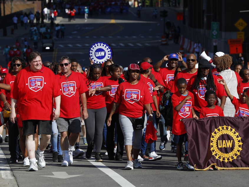 caption: United Auto Workers members walk in the Labor Day parade' in Detroit, Monday, Sept. 2, 2019.