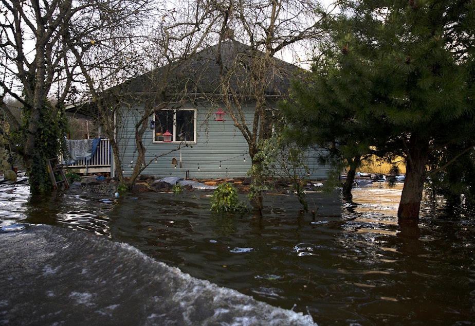caption: A home is shown surrounded by floodwater along Old Day Creek Road on Tuesday, November 16, 2021, in Clear Lake.