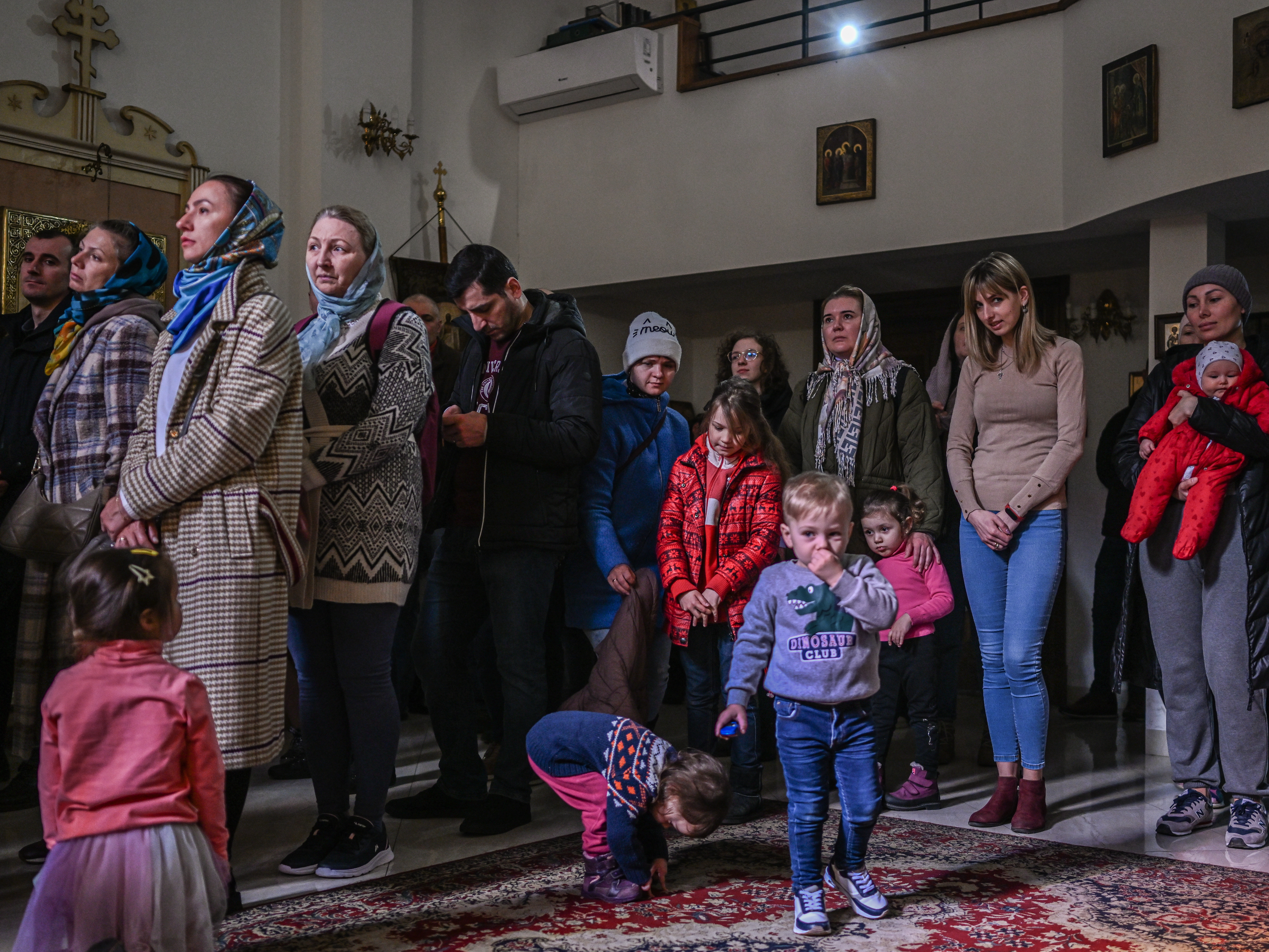 caption: People who fled the war in Ukraine and members of the Ukrainian diaspora pray in an Orthodox church in Krakow on Sunday.