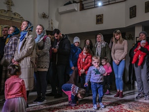 caption: People who fled the war in Ukraine and members of the Ukrainian diaspora pray in an Orthodox church in Krakow on Sunday.