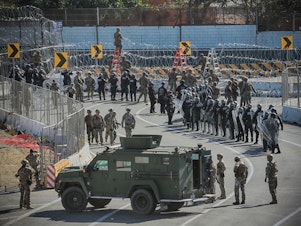 caption: U.S. military and border agents secure the United States-Mexico border at the San Ysidro border crossing south of San Diego, Calif. on Nov. 25.