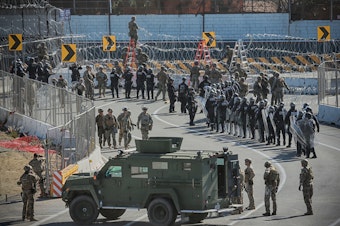 caption: U.S. military and border agents secure the United States-Mexico border at the San Ysidro border crossing south of San Diego, Calif. on Nov. 25.