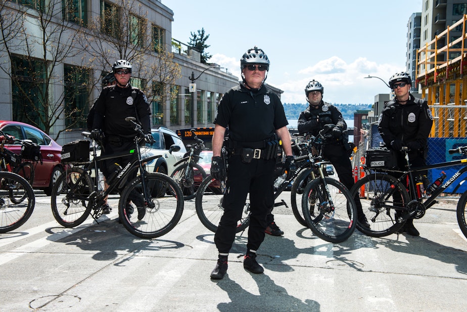 caption: FILE: Seattle police officers observe marchers moving down 4th Avenue during the Black Lives Matter rally in Seattle, Saturday April 15, 2017.