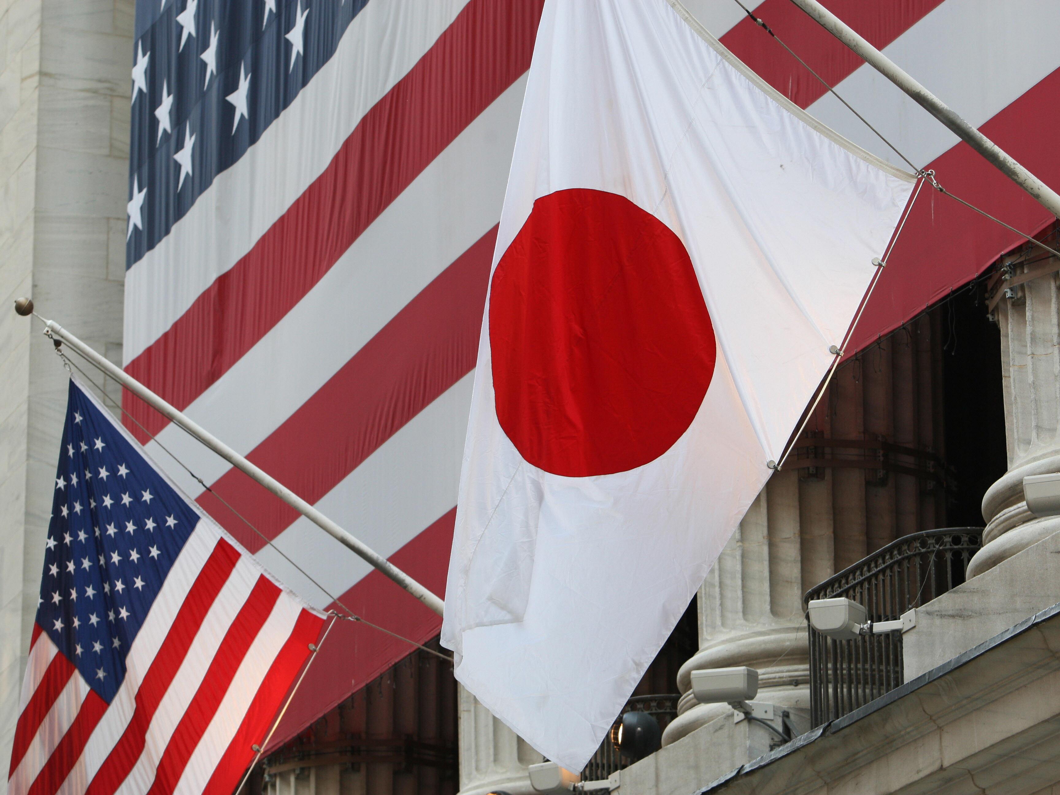 caption: The flag of Japan (right) hangs outside the New York Stock Exchange on May 5, 2008, in honor of Ryozo Kato, the ambassador of Japan to the United States at the time, ringing the opening bell.