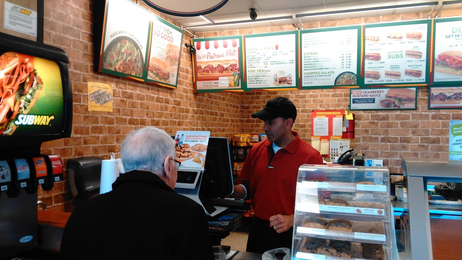 caption: Karam Maan says his Subway franchise has been hit hard by wage increases in Seattle