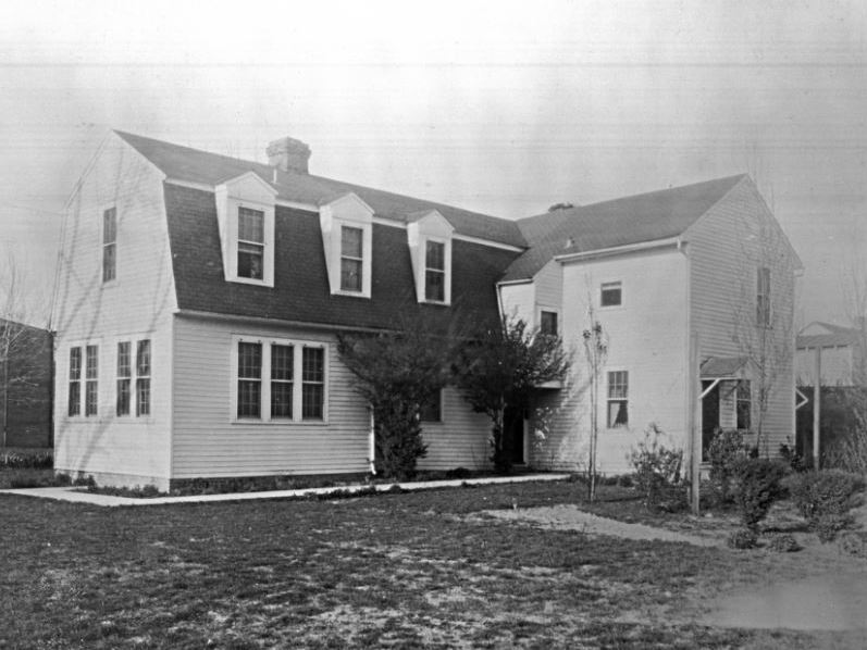 caption: The Bray School building in its original location on Prince George Street in Williamsburg, Va., seen around 1928.