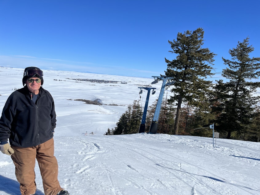 caption: General Manager Steve Hickman stands at the top of Badger Mountain Ski Area with Waterville, Washington, visible in the distance.